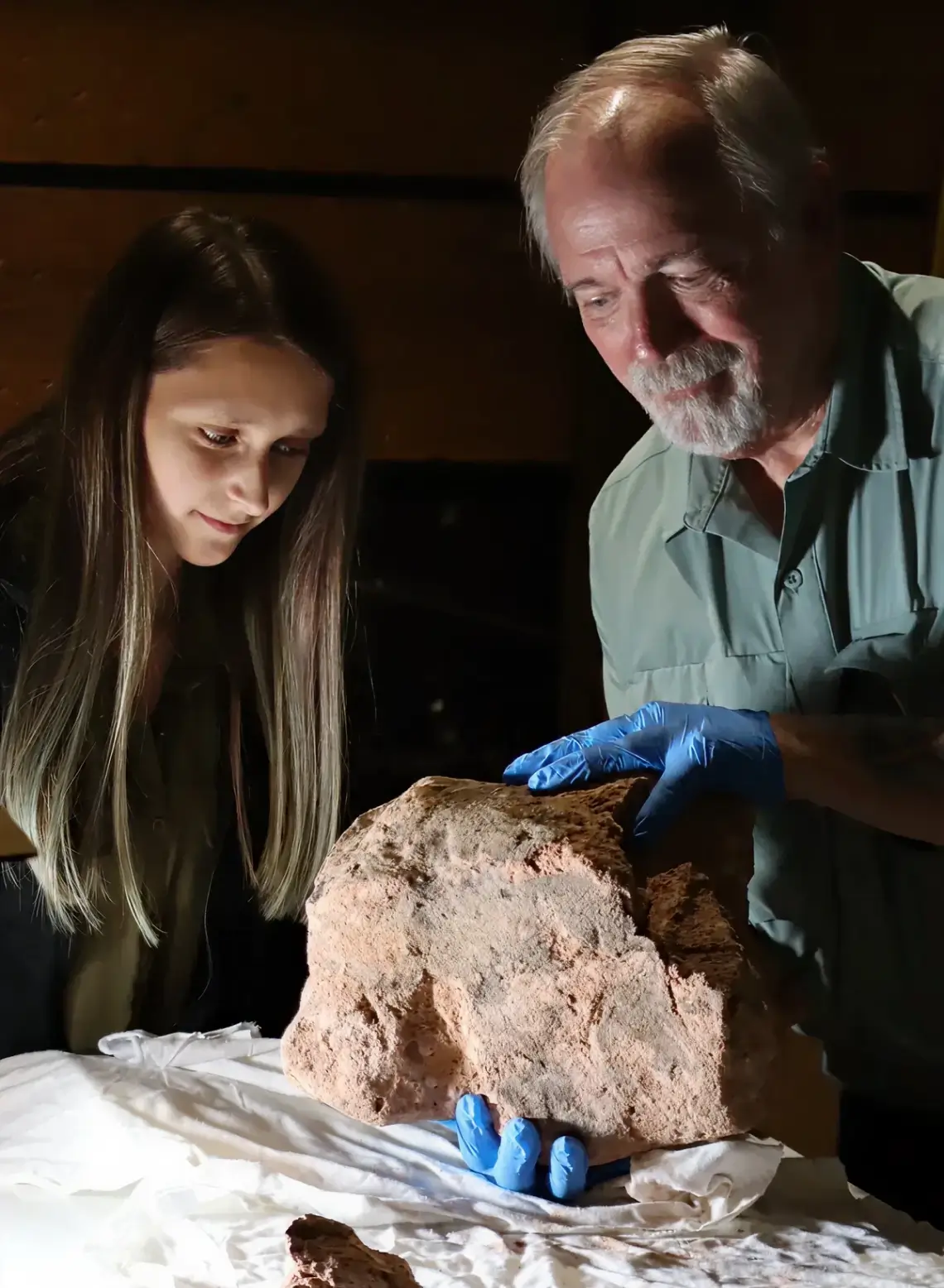 Archaeologists inspecting a stone artifact